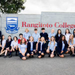 Image of Rangitoto College students gathered under College logo sign against a grey wall