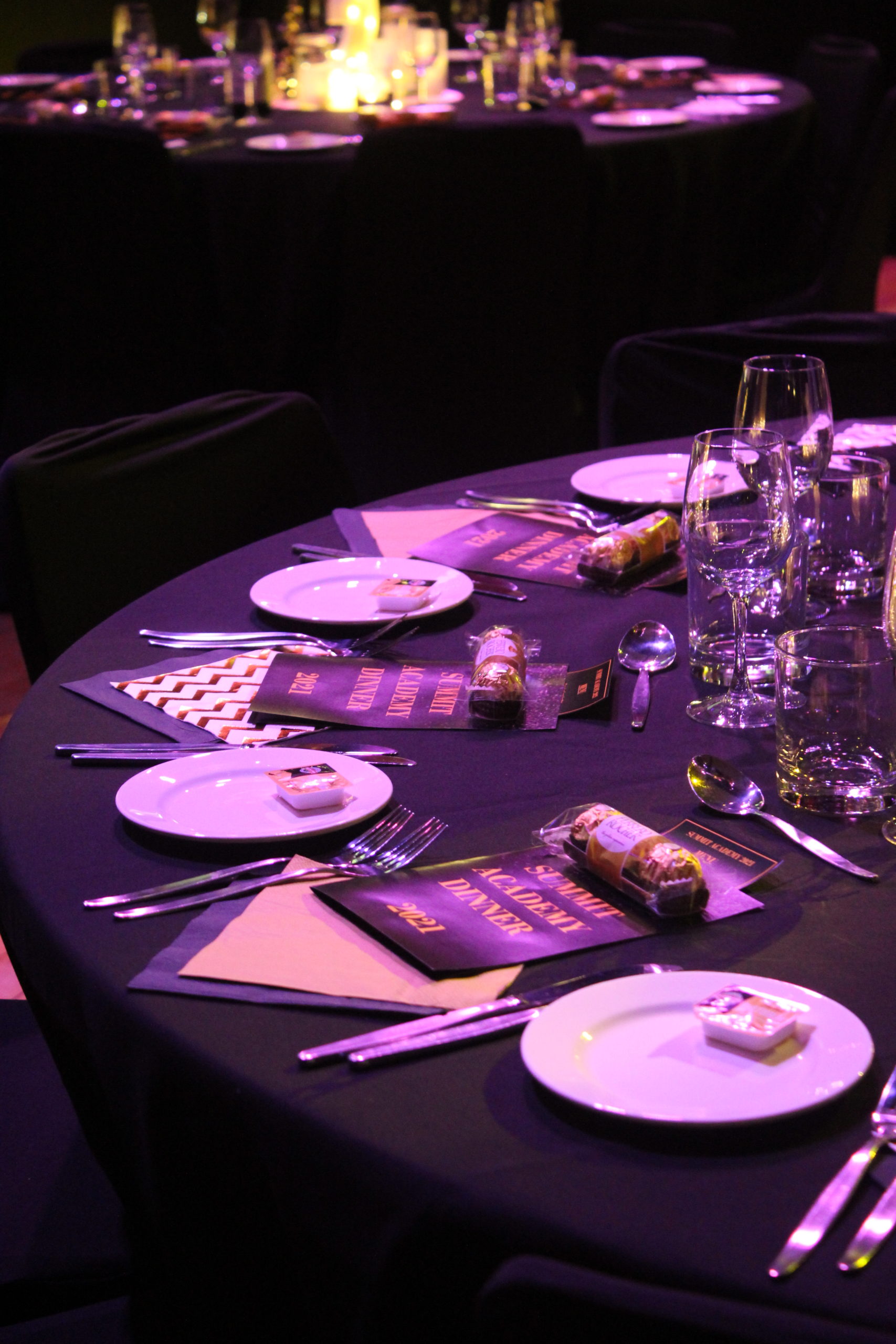 2021 Summit Academy Dinner place setting with chocolates and candles