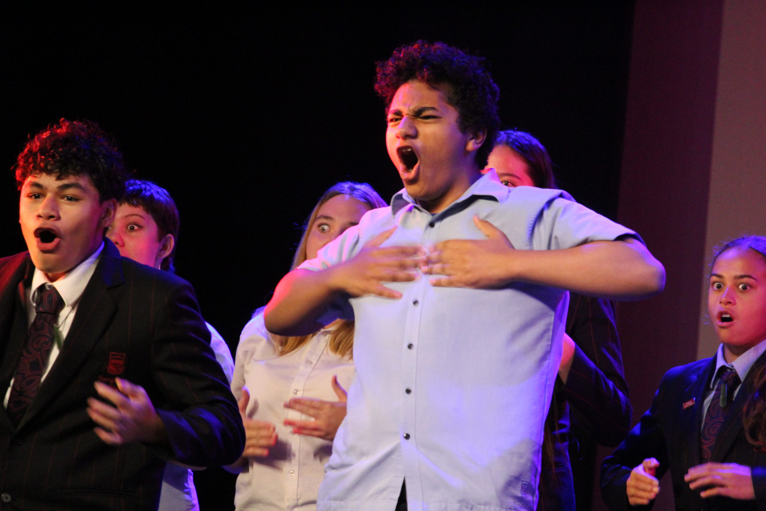 Image of lead male presenting a Kapa Haka, with 4 students in the background, at 2021 Rangitoto Alumni Summit Dinner