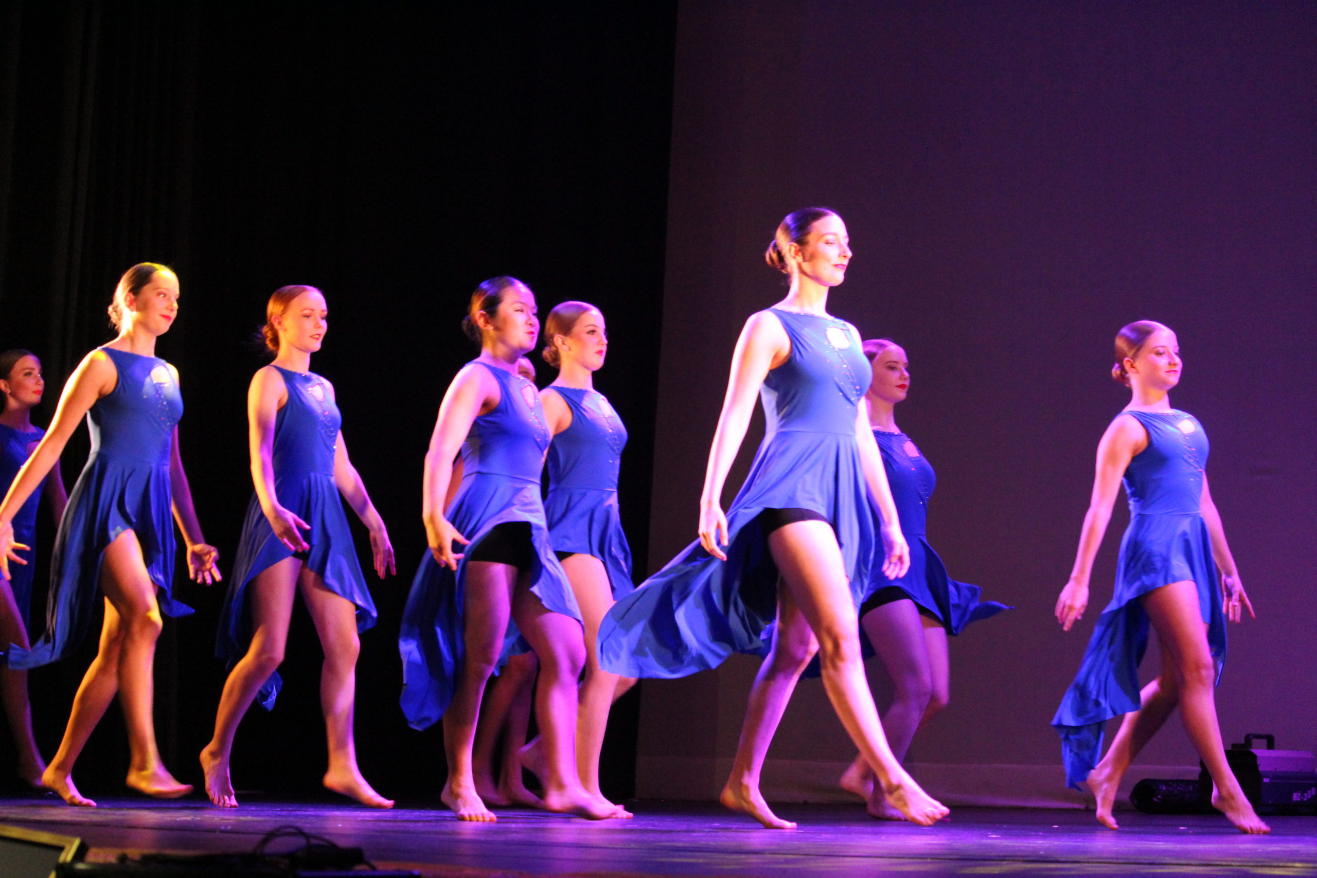 Rangitoto Ballet Troupe, all female, dressed in flowing purple ballet costumes dancing barefoot on a stage